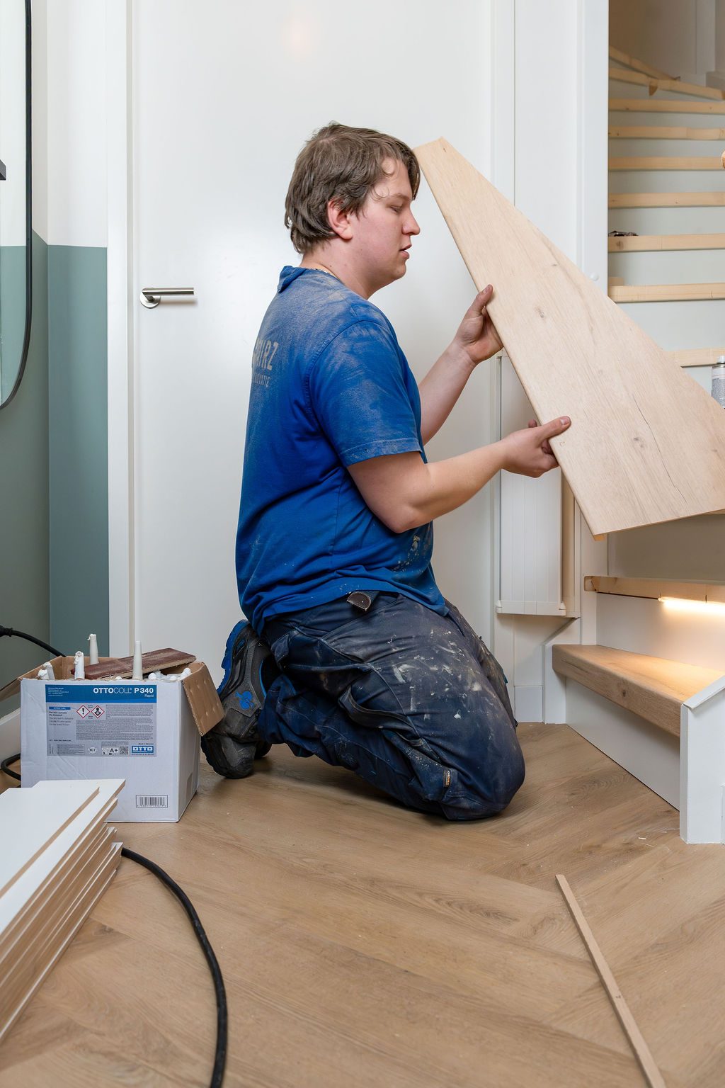 Monteur plaatst een eikenhouten traptrede in een woning